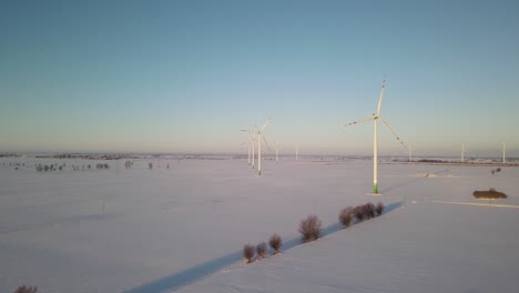 Windkraftanlagen-In-Der-Mitte-Der-Landwirtschaftlichen-Felder-In-Polen-Mit-Buntem-Himmel-Im-Hintergrund