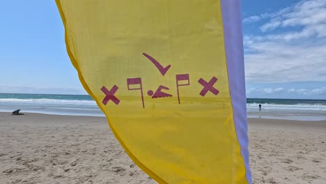 yellow flag waving on currumbin beach, gold coast