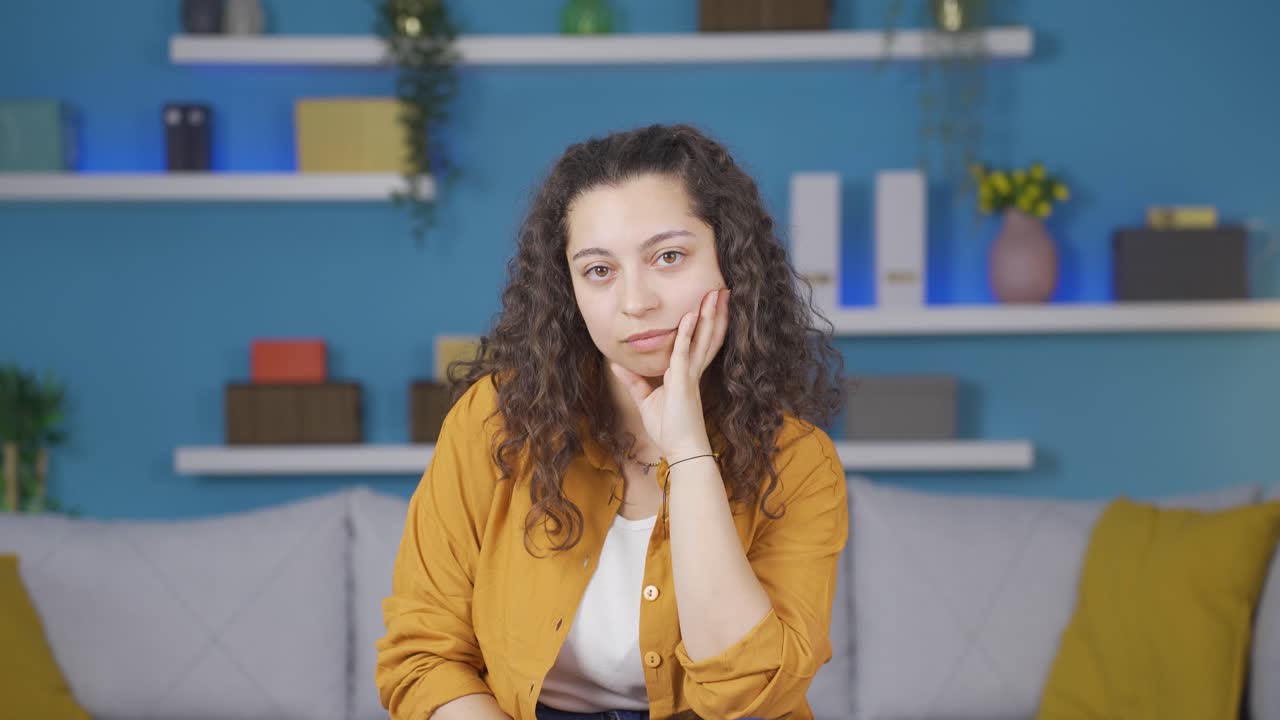 mujer joven mirando deprimida a la cámara.