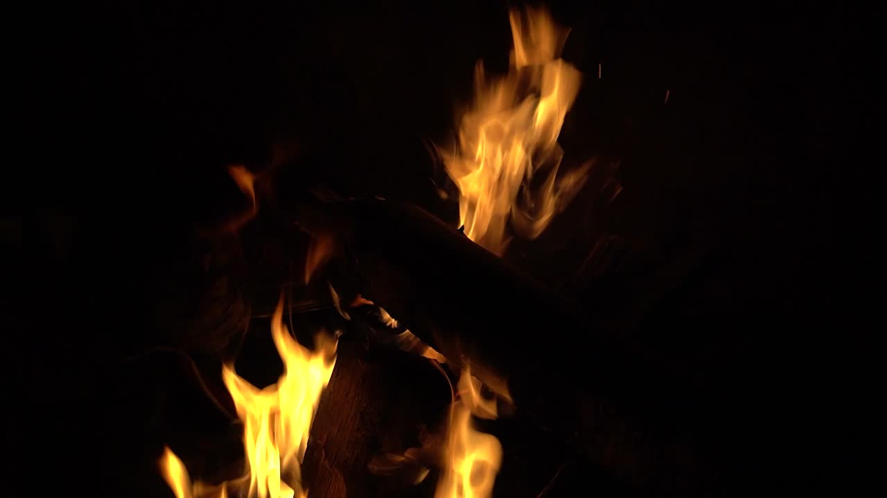 Fuoco che scoppietta nella notte buia, crepitio del fuoco, fiamma