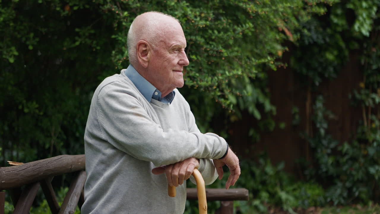 An elderly man resting on a bench with a walking stick