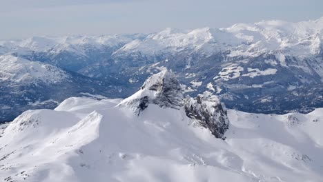 Snow-Covered-Rugged-Mountain-Peak-and-Landscape-AERIAL