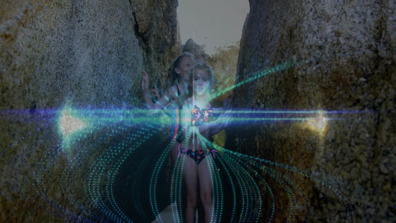 Two sisters emerging from beach crevice and activating tech rings wrapping around floaties