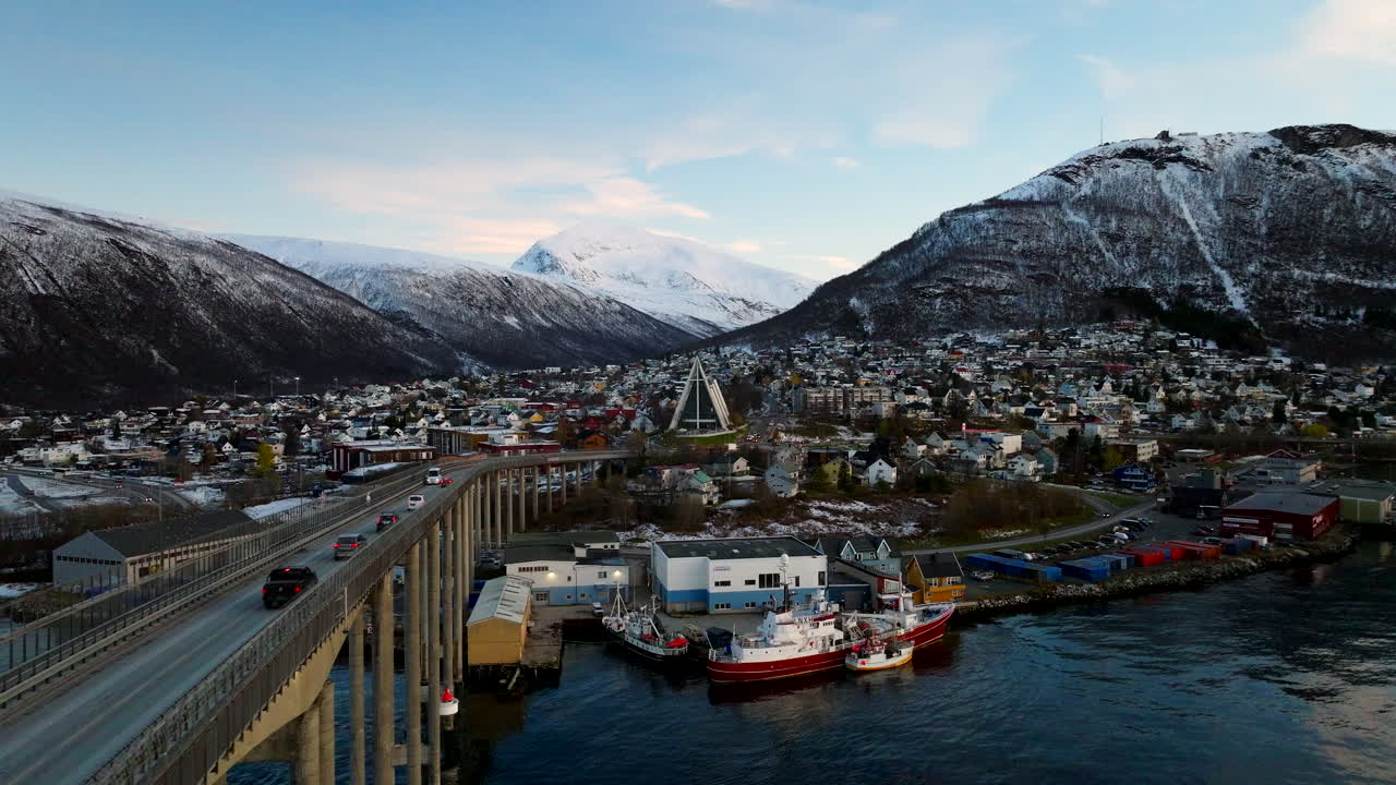 Winterliche Luftaufnahme neben der Tromsø-Brücke mit Verkehr und Blick auf die Eismeerkathedrale.