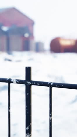 un primer plano de una valla de metal negro en un campo nevado