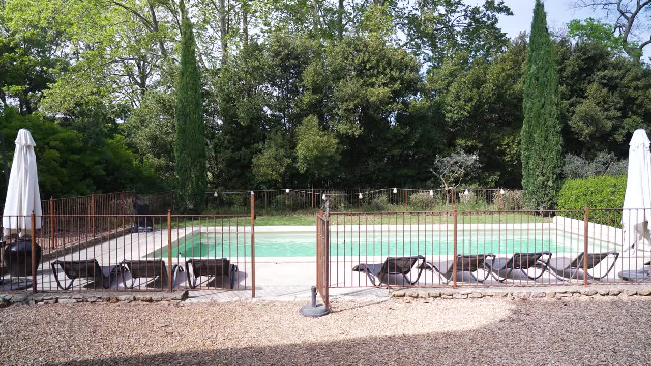 Slow dolly outside a villa in Nimes revealing a private pool in the garden