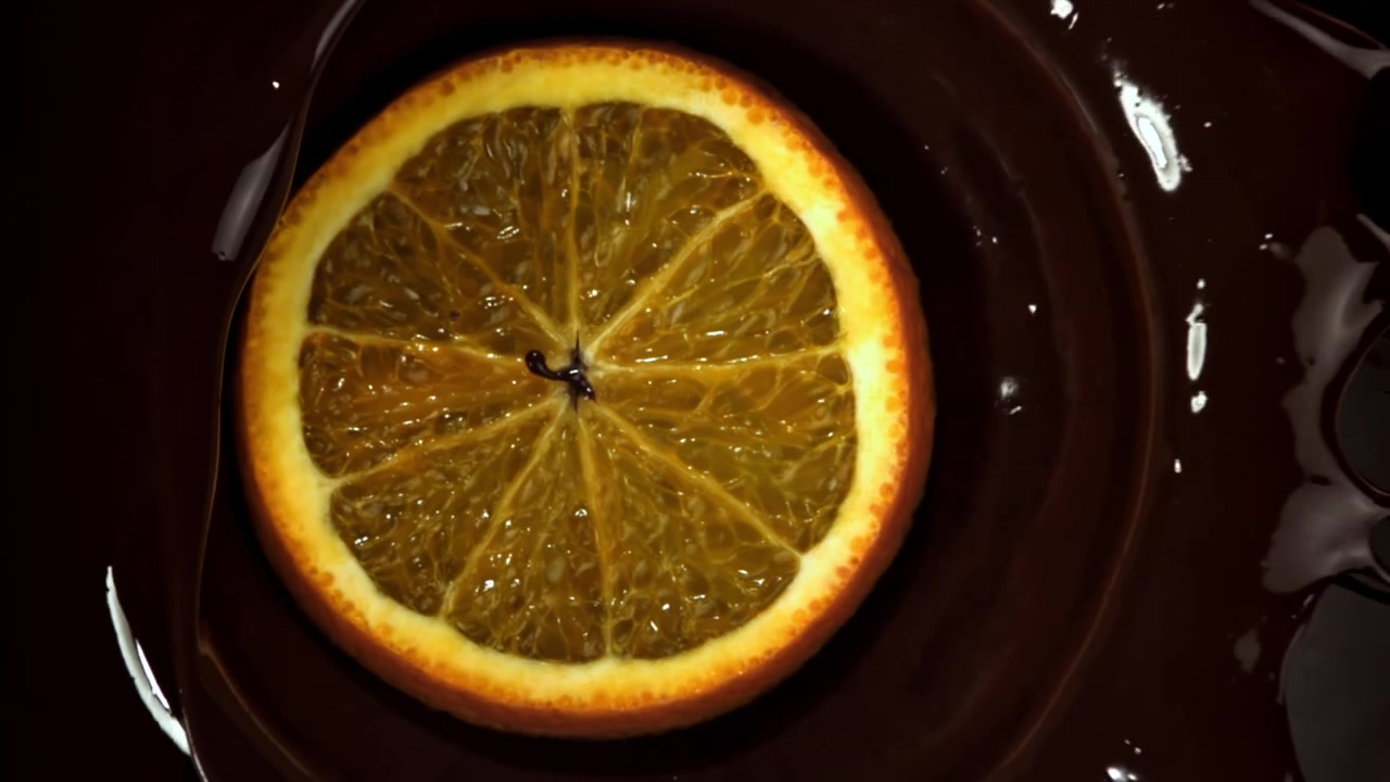 Fetta d'arancia immersa nel cioccolato fondente fuso