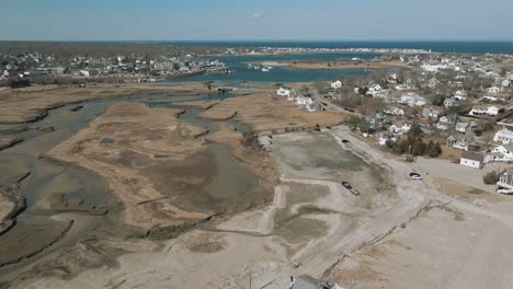 aerial flyby shot of a residential neighborhood and the salt marshes at low tide in scituate, ma