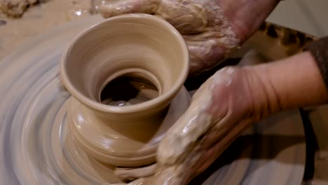 el alfarero está haciendo una olla de arcilla en la rueda del alfarero