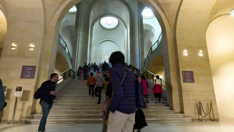 crowded grand staircase of the louvre museum in paris