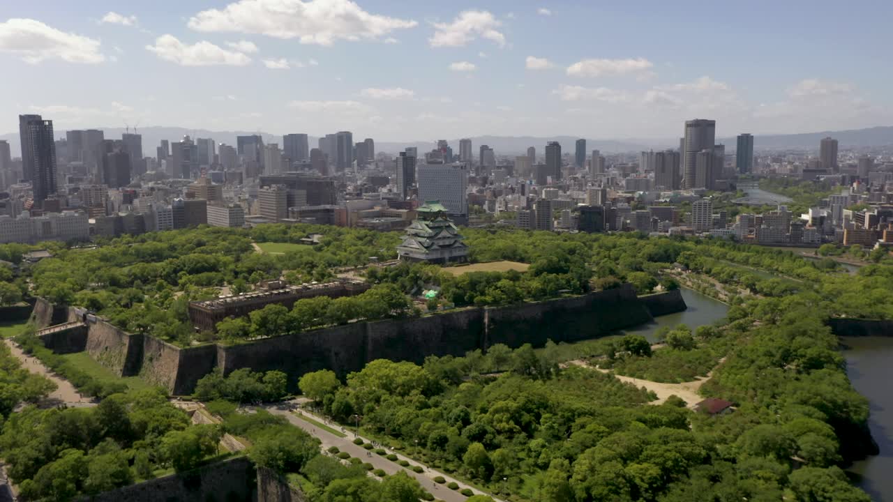 Aerial of Osaka Castle with park, moat, skyscraper, and city in Osaka, Japan