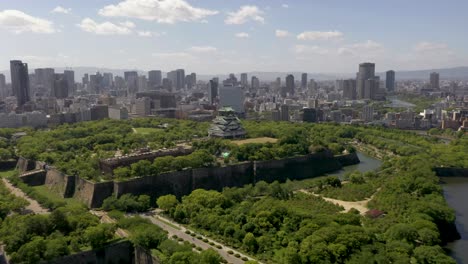 aerial of osaka castle with park, moat, skyscraper, and city in osaka, japan