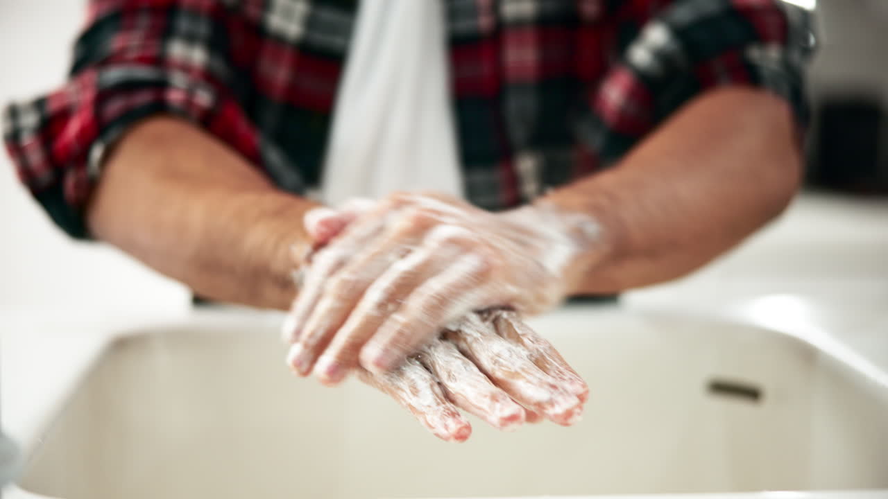 Man washing hands with soap in a sink