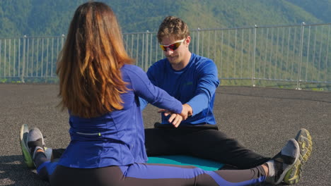 pareja estirándose al aire libre en las montañas