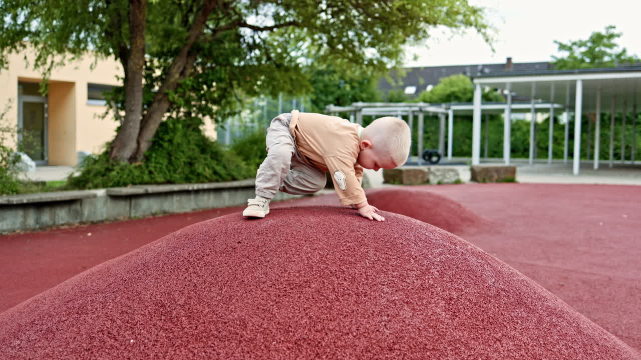 Un bambino vivace corre sulle colline del parco giochi. Il bambino corre e respira l'aria fresca. Il bambino in jeans e maglietta gioca all'aperto.