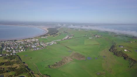 vuelo aéreo sobre stanley hacia campos verdes y granjas en tasmania, australia