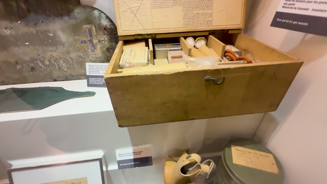 Vintage German first aid kit, gas mask, and medical supplies displayed under warm museum lighting