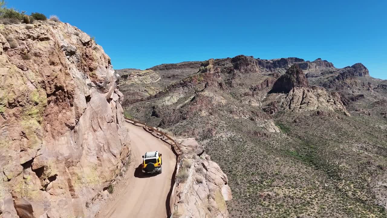 Aerial View of SUV driving on a Narrow Road on the Edge of a High Cliff. Apache Trail in Arizona, State Route 88