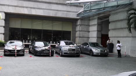 cars and valets at a hotel's bustling driveway.