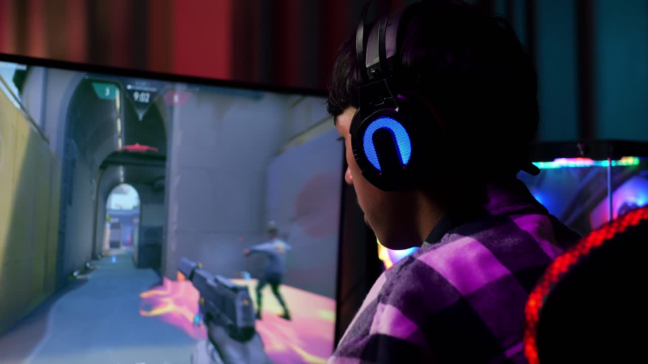 Primo piano di un gamer adolescente asiatico che perde mentre gioca a un videogioco al computer, videogioco sparatutto online