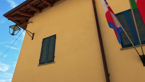 banderas expuestas en un edificio en cuneo, italia