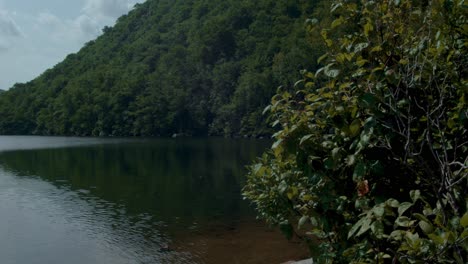 un lago tranquilo se encuentra frente a dos montañas verdes mientras la cámara gira