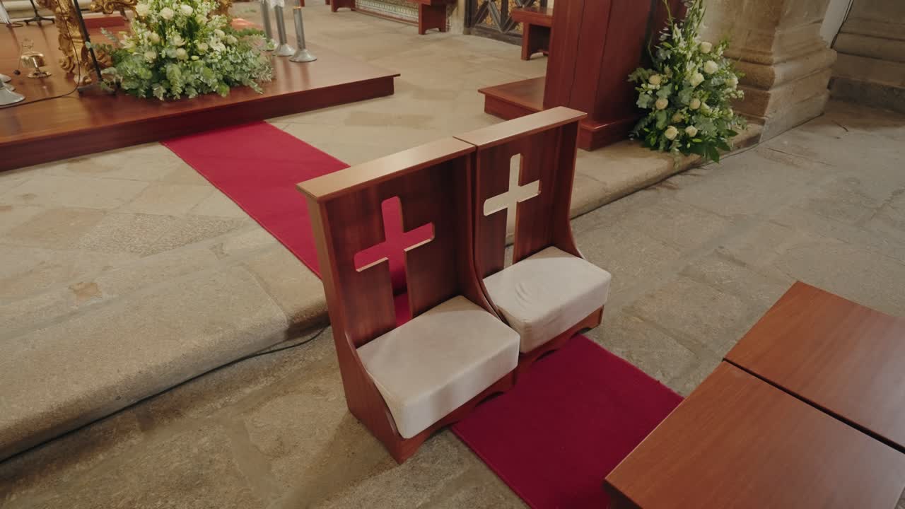 꽃으로 장식된 제단 옆에 십자가가 있는 나무 교회 의자
