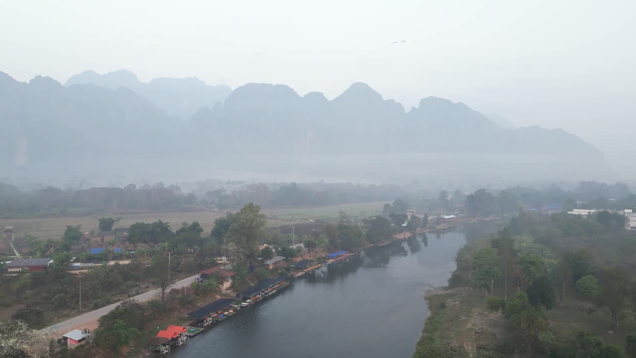 drone aerial shot of misty mountains and river in Vang Vieng, the adventure capital of Laos