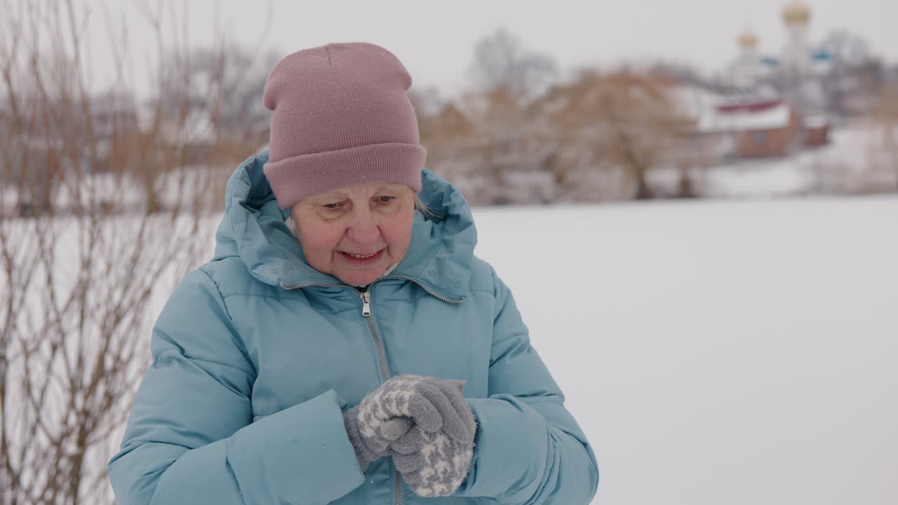 Donna anziana che si gode una giornata invernale nevosa