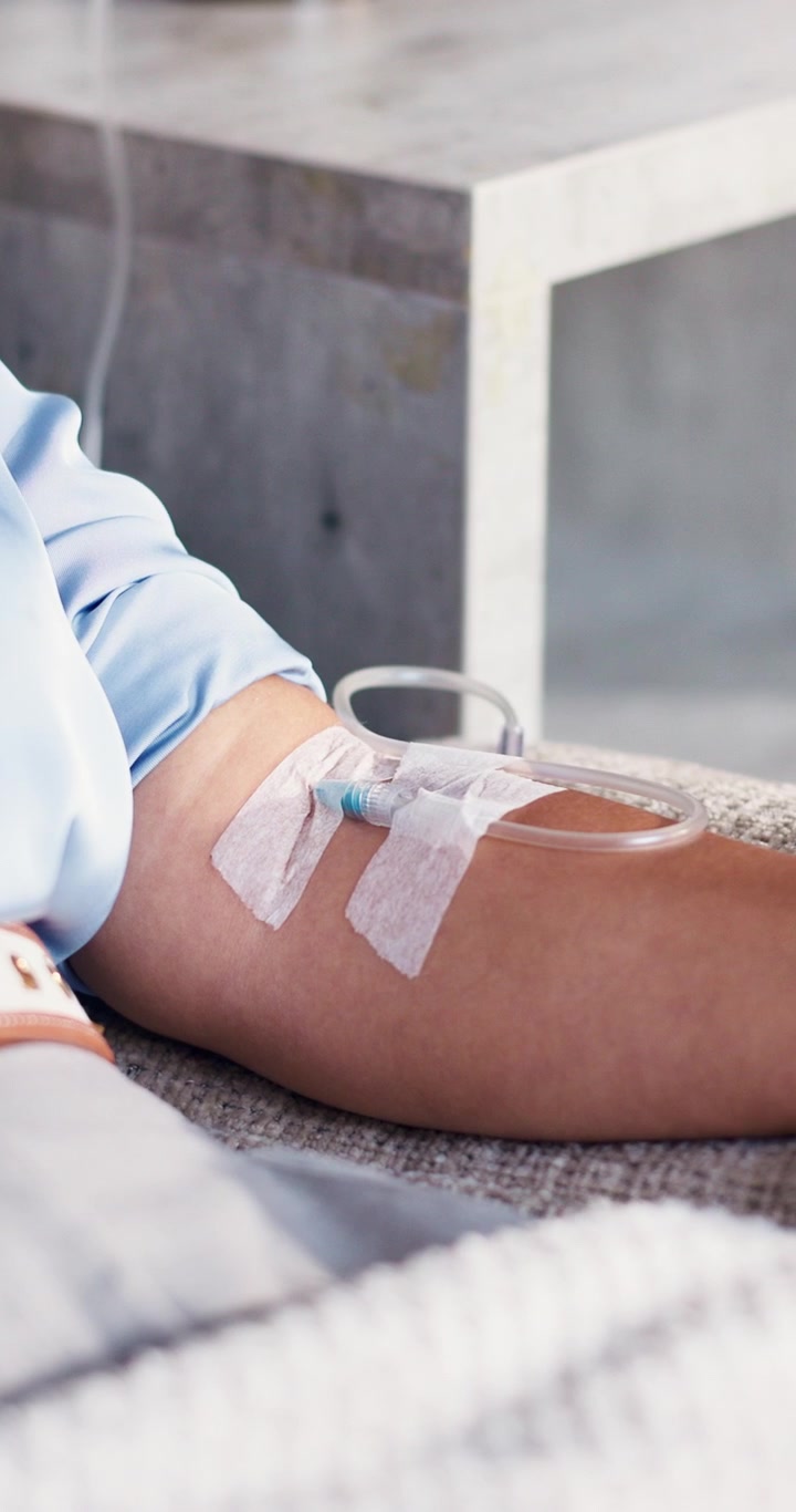Primo piano del braccio di un paziente con flebo endovenosa
