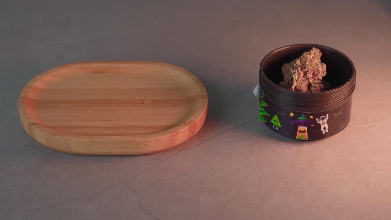 macho caucásico vierte un cogollo de marihuana en una bandeja pequeña para su procesamiento