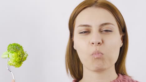 close-up portrait of woman eating broccoli. eating healthy.