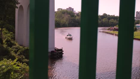 The-Cuyahoga-River-on-a-clear-day-with-a-boat-passing-by-through-a-railing