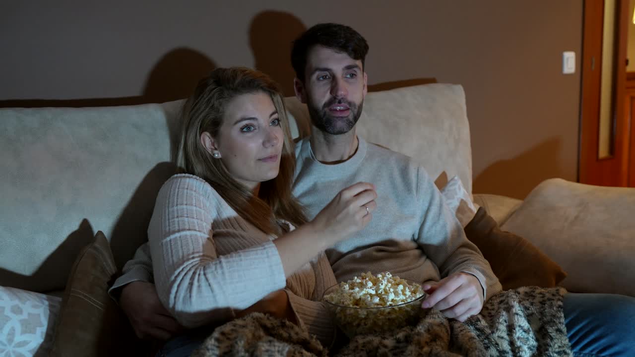 Una coppia che si diverte una serata al cinema con i popcorn.