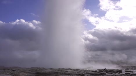 powerful geyser erupting against blue sky