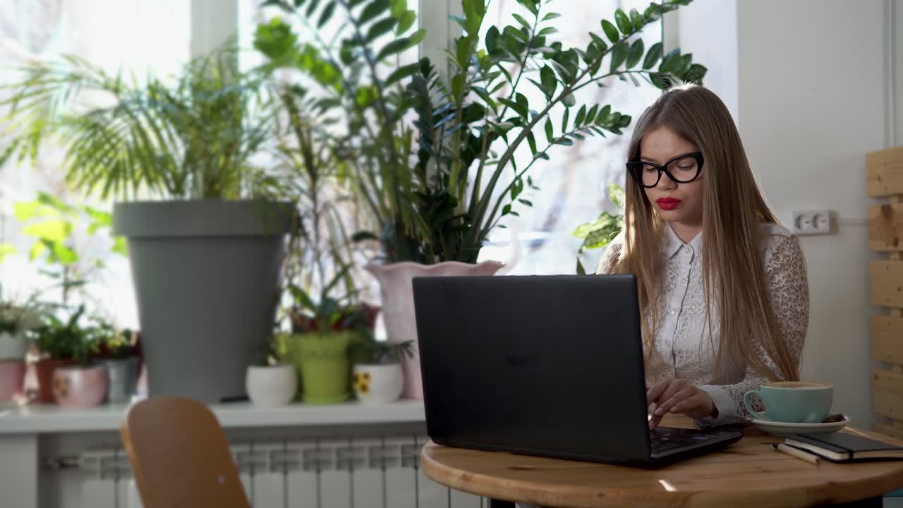 Donna che lavora al portatile in un caffè