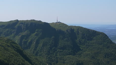 drone push-in from the northern side, capturing the dramatic slopes of mount ulriken and expansive summer scenery in the mountains