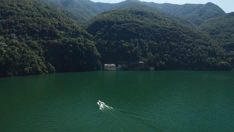 Speedboat-cruising-on-Lake-Como-with-lush-green-hills-and-clear-waters,-Ossuccio,-Italy,-sunny-day