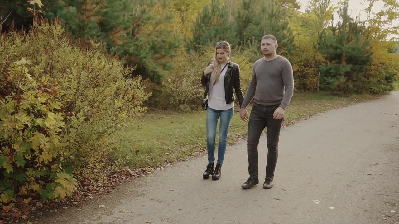 Una pareja caminando en el parque de otoño.