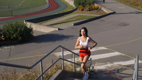 pretty sportive girl runs up stairs at the sports complex, slow motion
