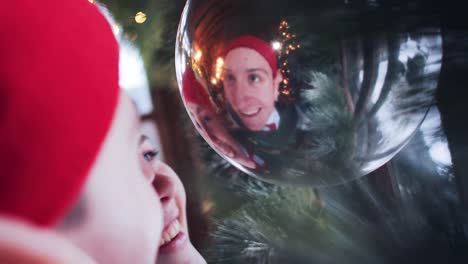 santa claus funny elves play with a christmas toy that hangs by the window