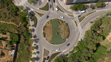 suburban roundabout with driving vehicles in spain, aerial top down view