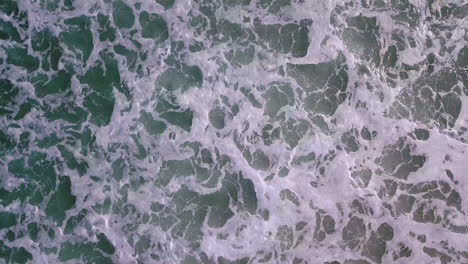 imágenes aéreas de olas rodando hacia la costa frente a la costa del sur de california
