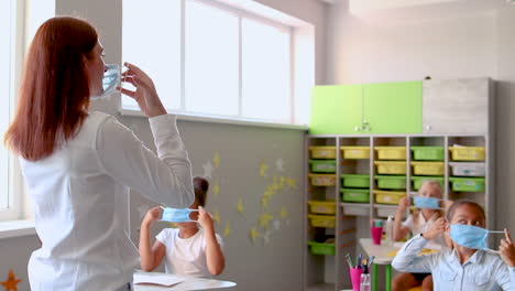 female teacher teaches children to put on a face medical mask