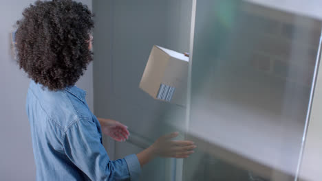 happy biracial woman receiving parcel at home, slow motion