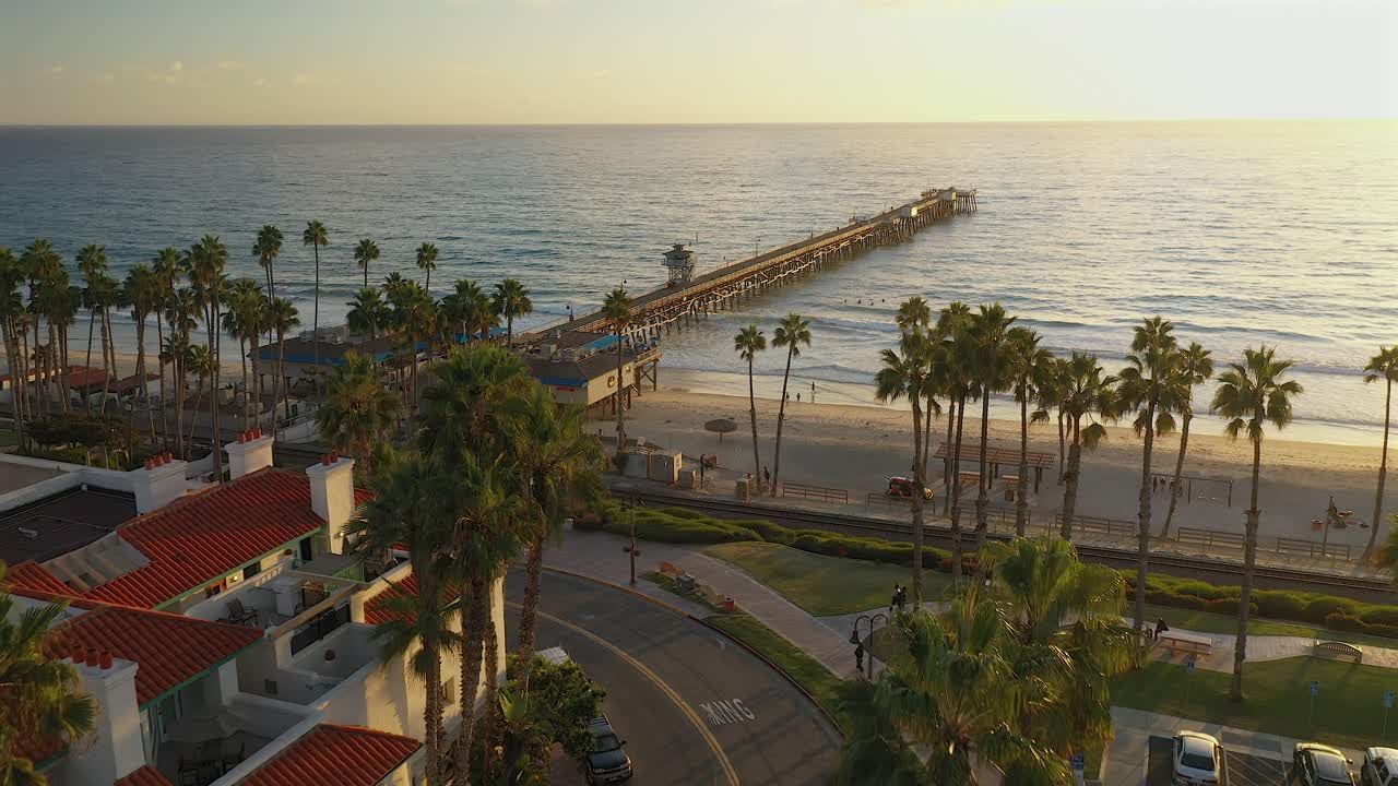 Luftfoto af molen i San Clemente, Californien, over toppen af høje palmer.