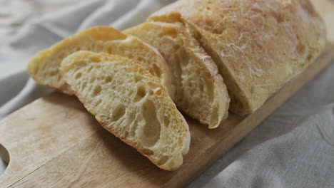 video of bread on chopping wooden board on wooden worktop