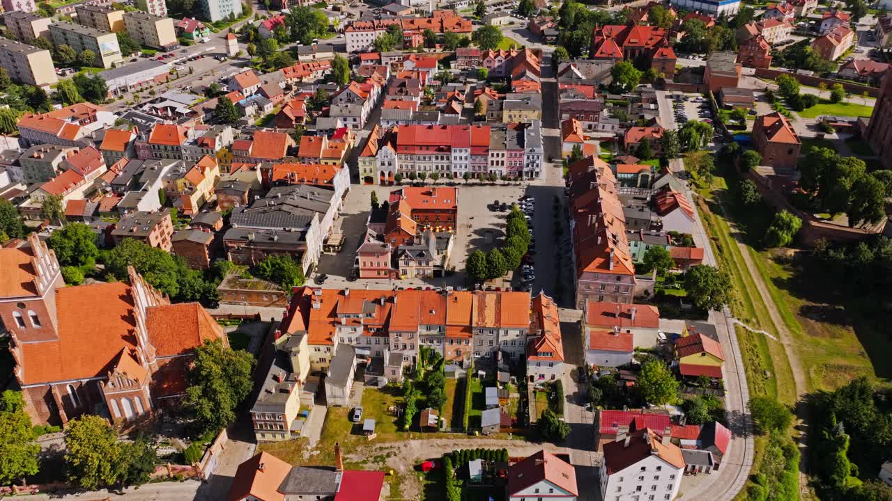 Drone shot showing medieval Gniew castle and colorful houses in summer