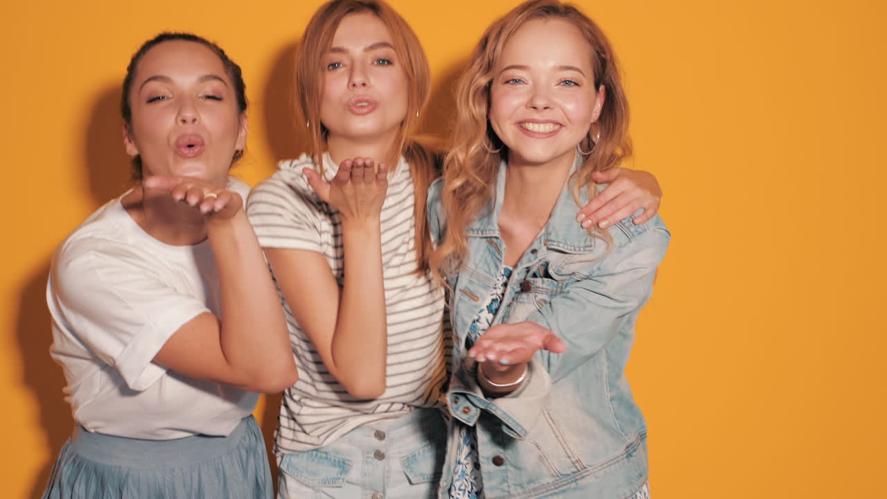 세 명의 여성 친구들이 사진 촬영을 위해 포즈를 취하고 있습니다.