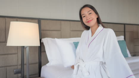 beautiful asian girl in bathrobe smiling to the camera